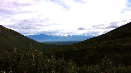 Scenic view of mountains against cloudy sky