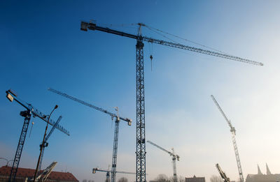 Construction cranes on a building site on a blue sky background