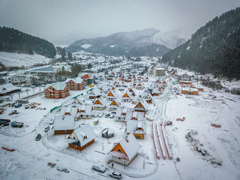 High angle view of townscape by snow covered mountain