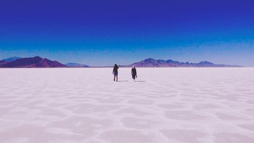 Rear view of people walking at bonneville salt flats