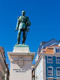 Low angle view of statue against blue sky