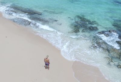 High angle view of man standing on shore at beach