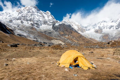 Tent on mountains against sky during winter