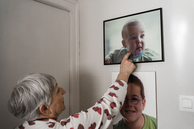 Grandmother with broken arm looking at pictures of her grandson