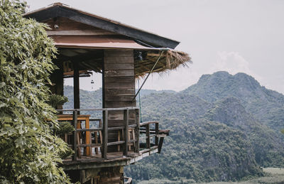 House by tree and mountain against sky