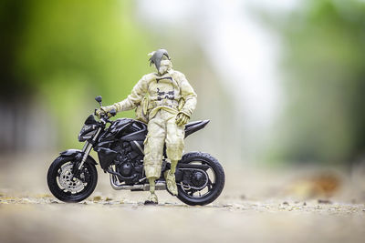 Close-up of figurine with motorcycle on road
