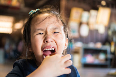 Close-up portrait of cute girl eating food