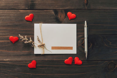 Valentine card with red heart on wooden background