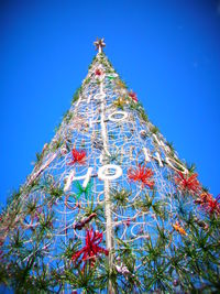 Low angle view of christmas tree against blue sky