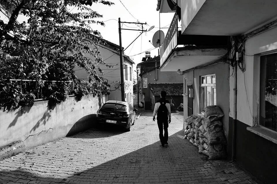 building exterior, architecture, built structure, the way forward, walking, men, rear view, full length, street, person, lifestyles, alley, house, city, residential structure, city life, leisure activity