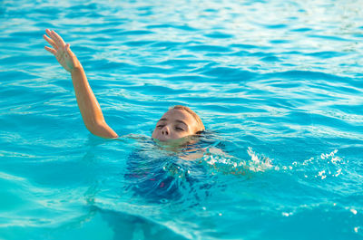 Cute girl drowning in swimming pool