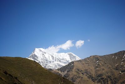 Scenic view of snowcapped mountains against blue sky