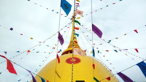 Low angle view of colorful flags decorated on temple against sky