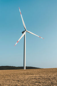 Windmill on field against clear sky