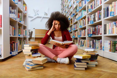 Young woman sitting on book