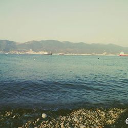 Scenic view of sea and mountains against sky