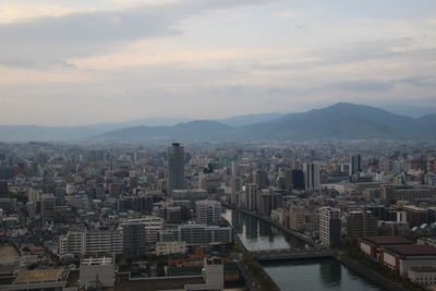 Aerial view of buildings in city against sky during sunset