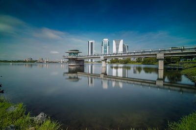 Modern government buildings and jetty reflection in lake against sky