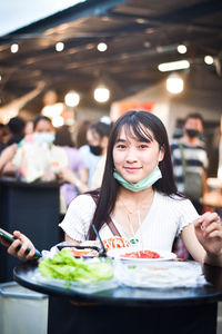 Portrait of woman eating food in restaurant