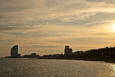 Silhouette of buildings against cloudy sky