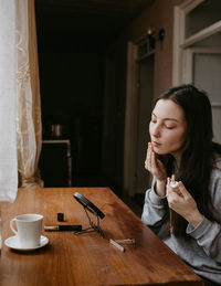 Portrait of young woman using mobile phone at home