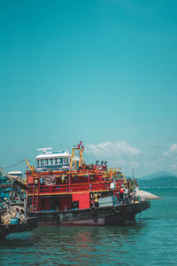 Fishing boat on sea against clear blue sky