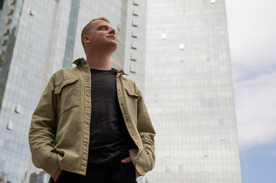 Side view of man standing against building