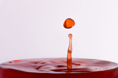 Close-up of ice cream over water against white background