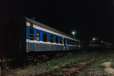 Train on railroad tracks against clear sky at night