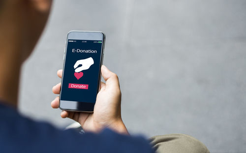 Midsection of person holding smart phone