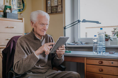 Man using mobile phone while sitting on chair