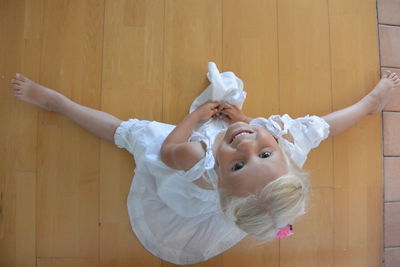 Portrait of cute girl looking away while standing on wooden floor