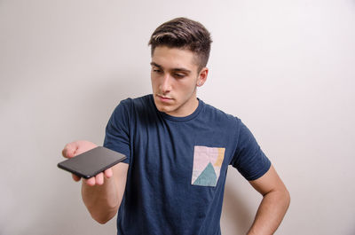 Young man using mobile phone against white background