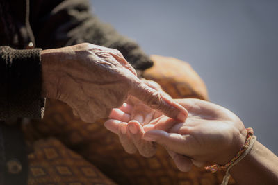 Close-up of hand holding hands outdoors