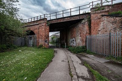 Empty road amidst buildings against sky