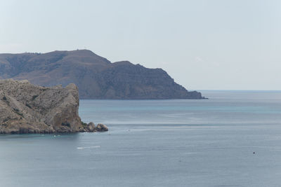 Scenic view of sea and mountains against sky