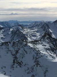 Aerial view of snowcapped mountains against sky