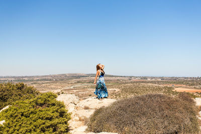 Full length of woman on landscape against clear sky