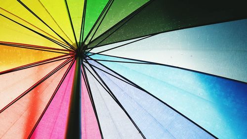 Low angle view of colorful umbrella against blue sky
