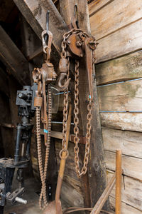 Close-up of rusty chain hanging on wood