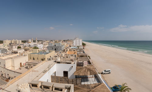 High angle view of buildings by sea against sky