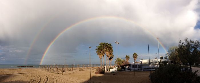 Panoramic view of rainbow over trees against sky