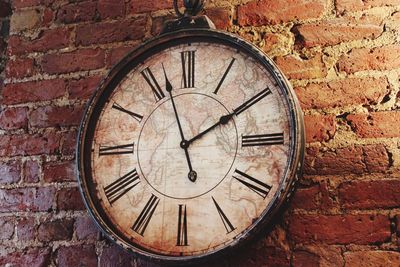 Close-up of clock on brick wall
