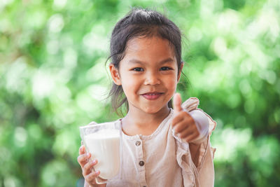 Portrait of smiling girl holding ice cream outdoors