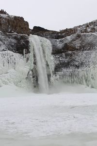 Scenic view of waterfall against sky