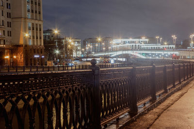 Illuminated bridge over canal in city at night