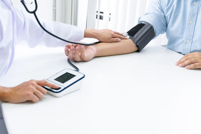Midsection of man using laptop on table