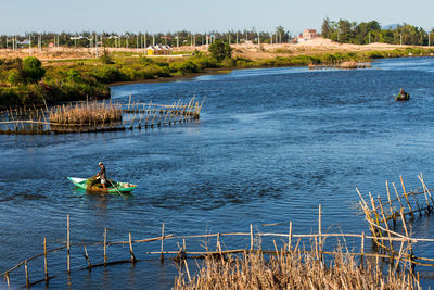 Man standing on boat in lake