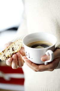 Woman holding coffee cup and cake