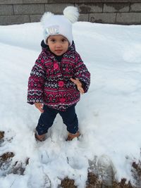 Girl standing on snow covered field